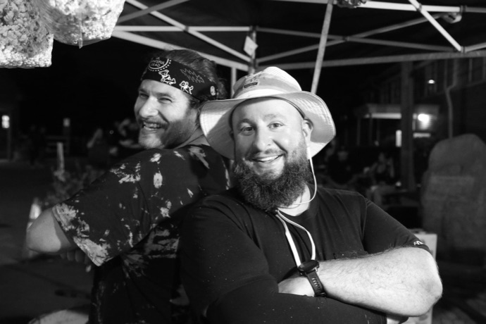 Two of the crew back to back under the tent at a night market
