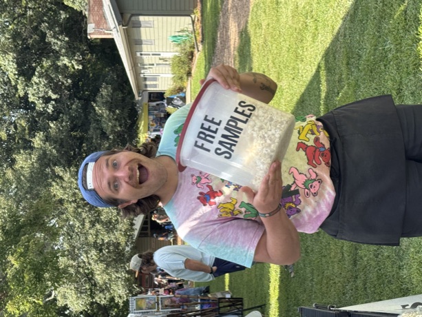 A crew member grinning with the free samples bucket