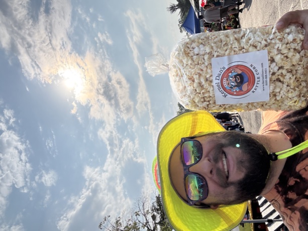 The Kernel in his sun hat holding up a fresh bag at the market