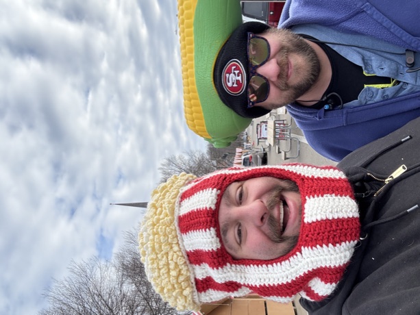 The crew in a popcorn-bucket balaclava and a corn hat at a winter market